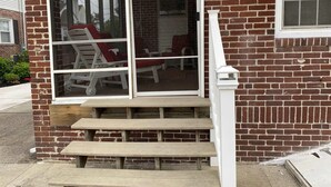 A brick building with a large glass door, a set of wooden steps, and a white railing. - one block to the boardwalk and the beach (Ventnor City)