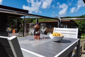 Enjoy a romantic dinner for two in this serene outdoor dining area, complete with a beautifully set table and a view of the surrounding cityscape.