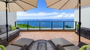 A balcony with outdoor furniture, a view of the ocean, and a railing. - Sapphire Lotus~Ocean Front~A/C~Pool~BBQ (Princeville)