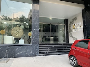 A modern building entrance with a glass facade, marble steps, and decorative elements. - K Building (Ho Chi Minh City)