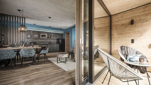 A modern kitchen with a dining area, featuring a large table, chairs, and a hanging light fixture.