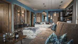 A modern living room with a large sectional sofa, a wooden accent wall, and a dining area in the background.