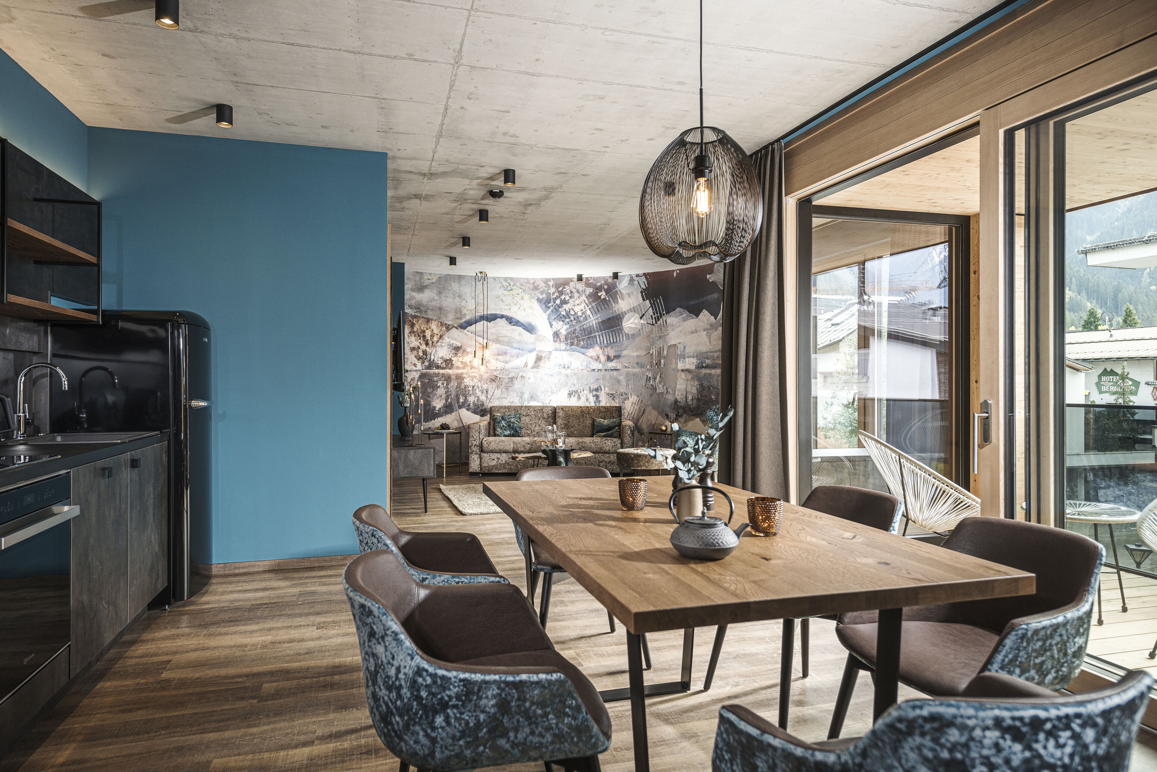 A modern kitchen with dark cabinetry and a wooden dining table.