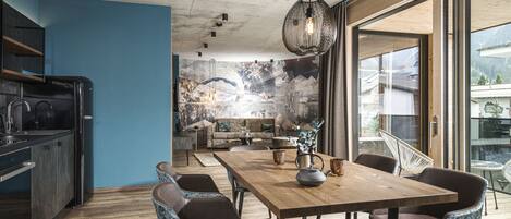 A modern kitchen with dark cabinetry and a wooden dining table.