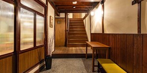 A traditional wooden interior with a staircase leading to an upper floor.