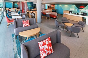 A modern lounge area with sofas, tables, and a counter.