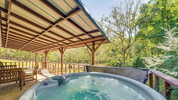 A hot tub under a wooden pergola with a view of a forested area. - Rustic Cabin w/ Hot Tub Near Broken Bow Lake! (Broken Bow)