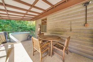An outdoor wooden deck with a hot tub, wooden chairs, and a table. - Rustic Cabin w/ Hot Tub Near Broken Bow Lake! (Broken Bow)