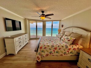 Une chambre à coucher avec un lit, une commode et un ventilateur de plafond.
