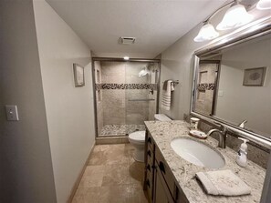 A modern bathroom with a walk-in shower, a vanity with a sink, and a large mirror. - Shores Club Direct Oceanfront 3/3 on Traffic Free Beach - Unit 901 (Daytona Beach Shores)
