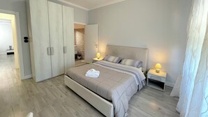 A modern bedroom with a large bed, a wardrobe, and a bathroom visible through an open door. - At the sight of the Baroque  (Lecce)