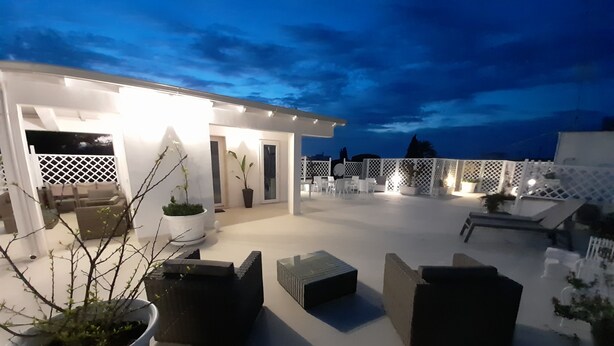 A rooftop terrace with outdoor seating, potted plants, and a white fence. - At the sight of the Baroque  (Lecce)