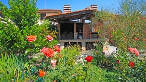 A house with a brick exterior, a wooden deck, and a garden with various plants and flowers. - Wonderful  villa with private pool, WIFI, hot tub, A/C, TV, terrace, pets allowed and panoramic ... (Montelupo Fiorentino)