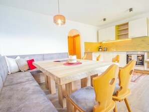 Een moderne keuken met houten kastjes, een inbouwoven en een koffieapparaat.