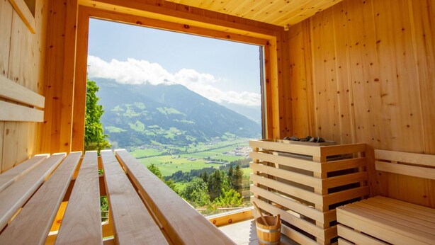 A wooden cabin with a large window offering a view of a mountainous landscape. - Nice apartment for 20 people with WIFI, TV and balcony (Schlitters)