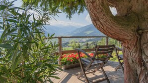 A wooden bench and table on a deck with a view of mountains and a lake. - Nice apartment for 20 people with WIFI, TV and balcony (Schlitters)