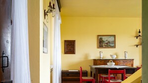 Un comedor con una mesa de madera, sillas rojas y un cuadro en la pared.