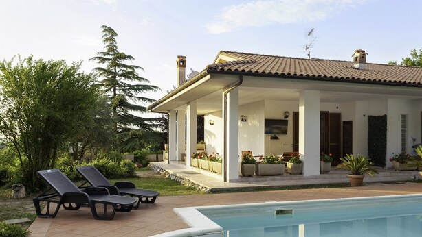 A poolside area with lounge chairs, a covered patio, and a swimming pool. - La Villa - Luxury Home (Configni)