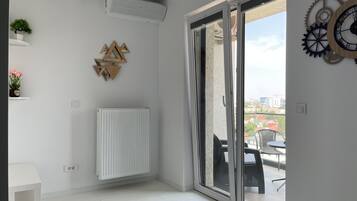A modern room with a sliding glass door leading to an outdoor area, a radiator, and decorative wall art.
