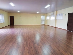 Comfortable room with a wooden floor, cream-colored walls, and two windows.