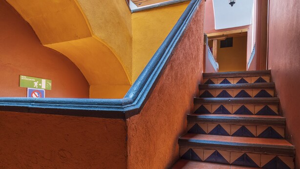 A staircase with a handrail and a sign indicating a pedestrian area. - Meson Real Hotel & Suites (Xalapa)