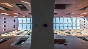 A modern interior with a central column, skylights, and a patterned floor. - Meson Real Hotel & Suites (Xalapa)