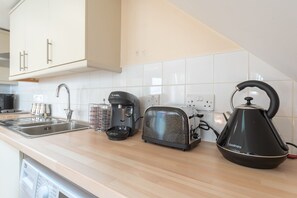 Enjoy cooking in this well-equipped kitchen with a stainless steel sink, coffee maker, toaster, and kettle.