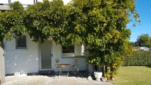 A house with a front porch, two chairs, and a small table.