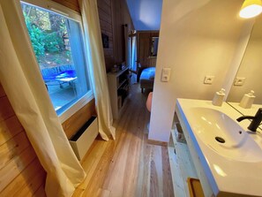 Ein Holzinnenraum mit einem Badezimmer, das ein Waschbecken und ein Fenster zeigt.