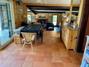 A rustic interior with a dining area, wooden furniture, and a fireplace. - Pool house in idyllic location A3695 (Lège-Cap-Ferret)