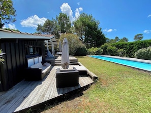 A wooden deck with outdoor seating and a pool. - Pool house in idyllic location A3695 (Lège-Cap-Ferret)