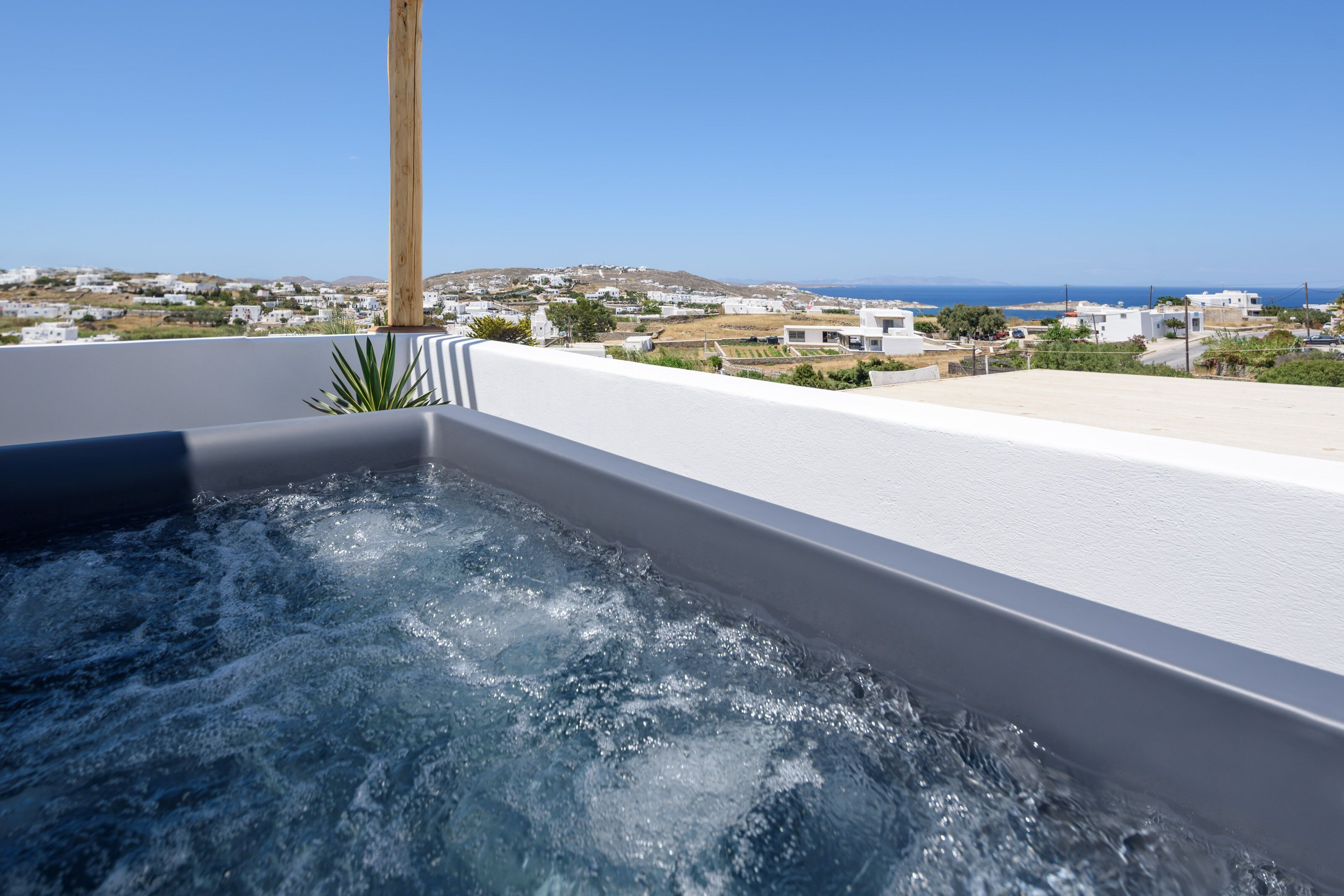 A hot tub with a view of a coastal town.