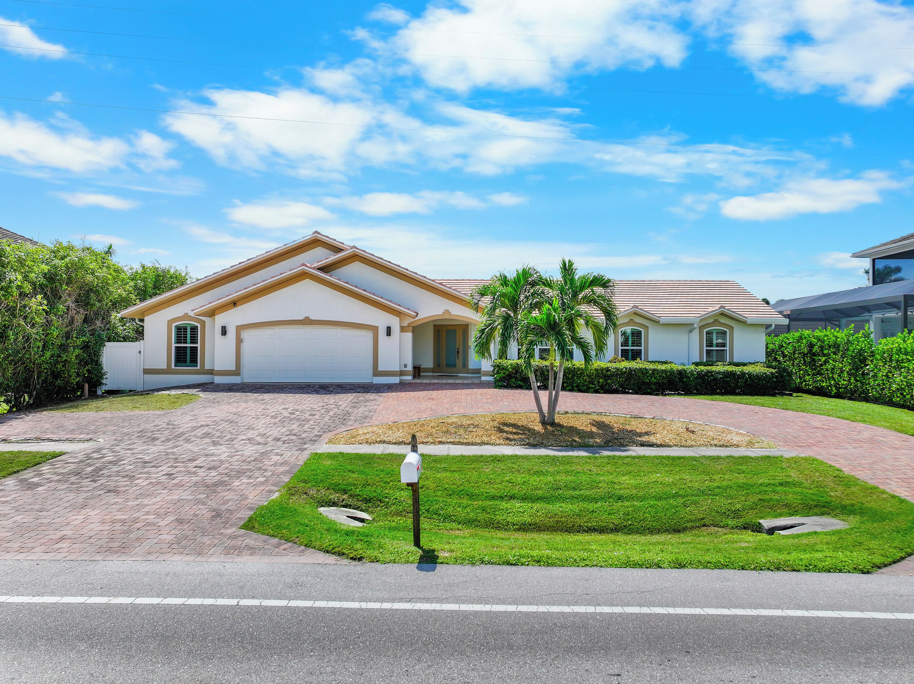 A residential house with a garage, a well-maintained lawn, and a mailbox.