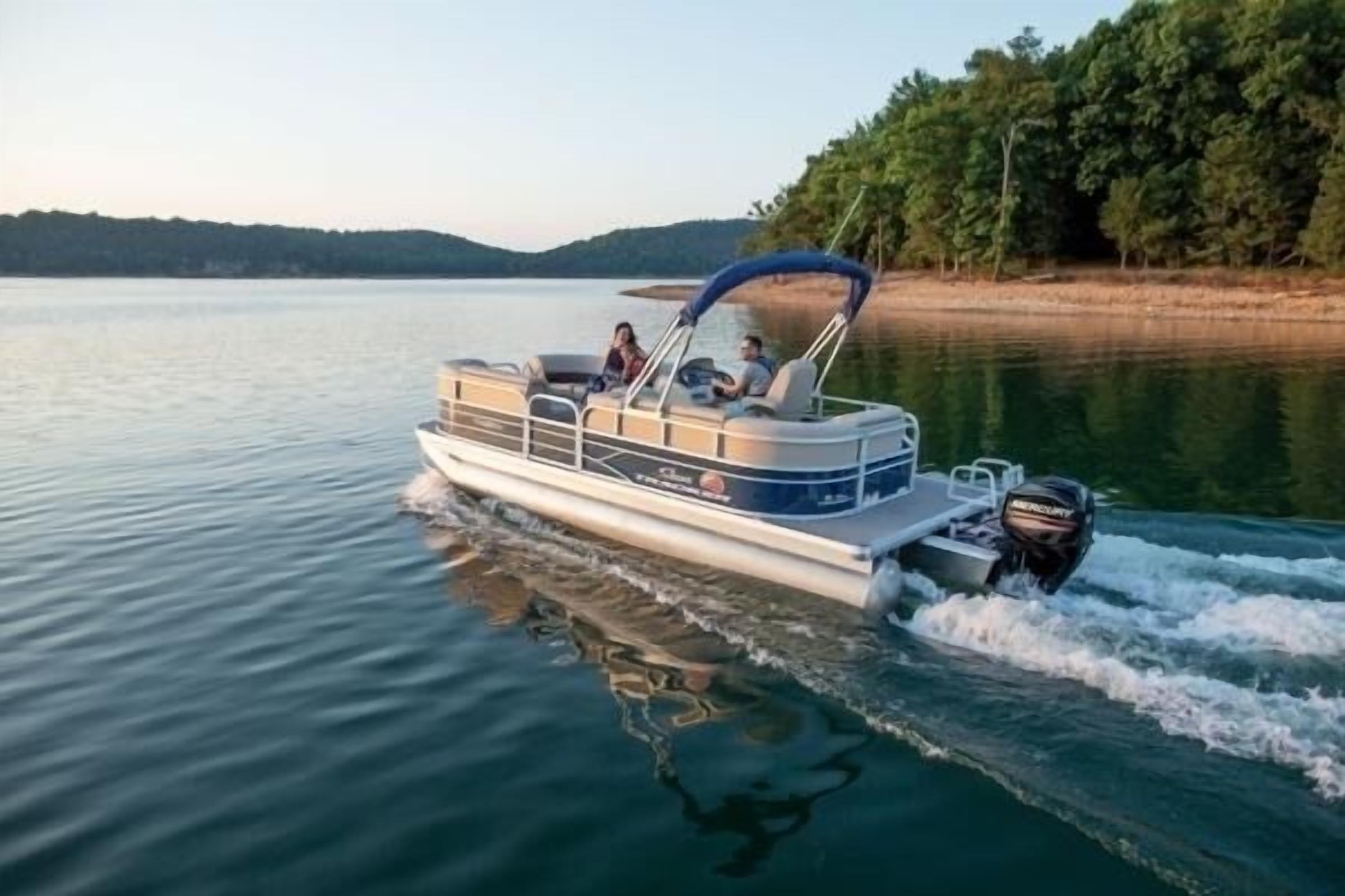 A motorboat on a calm lake with a canopy, surrounded by trees and hills in the background.