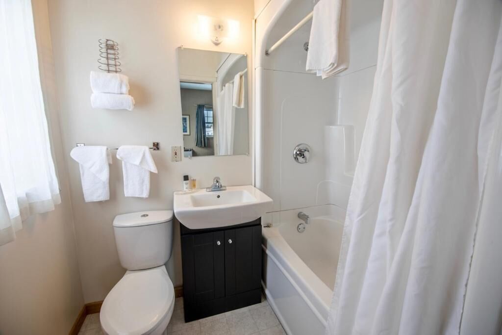 A bathroom with a toilet, sink, and bathtub.
