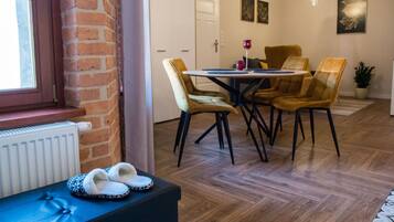 A dining area with a brick wall, a white door, and a table with four chairs.