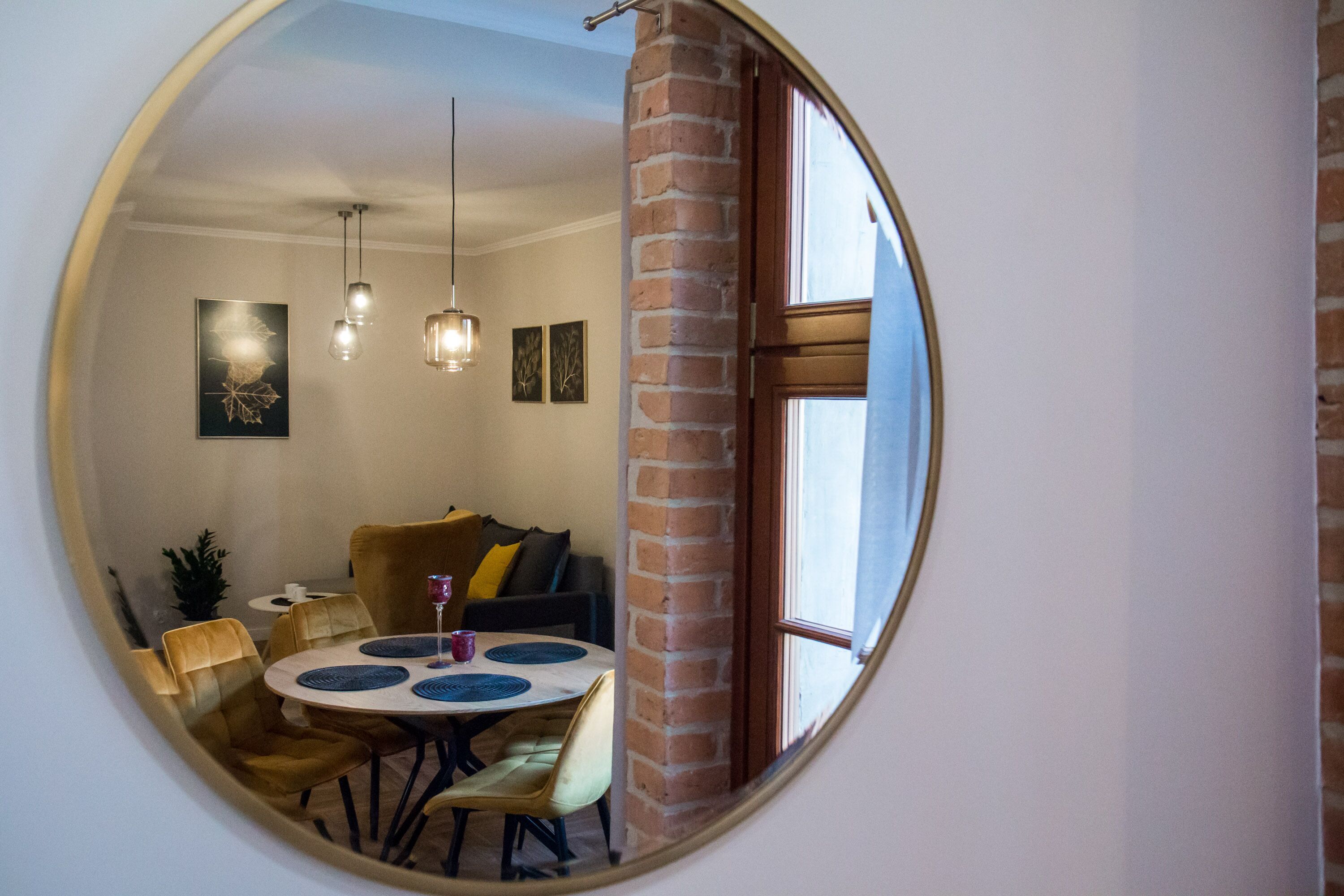 Un comedor con una mesa redonda, sillas e iluminación colgante.