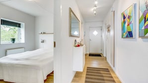 A hotel room with a bed, a bedside table, a mirror, a window with blinds, and a view of the outdoors. - 2 bedroom nice apartment in Hejls (Hejls)