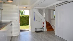 Moderni keittiö, jossa on valkoiset kaapit, puinen työtaso ja sisäänrakennettu uuni.