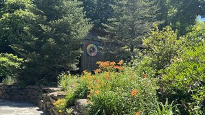 Un sendero de piedra que conduce a una estructura de madera con un mural colorido.