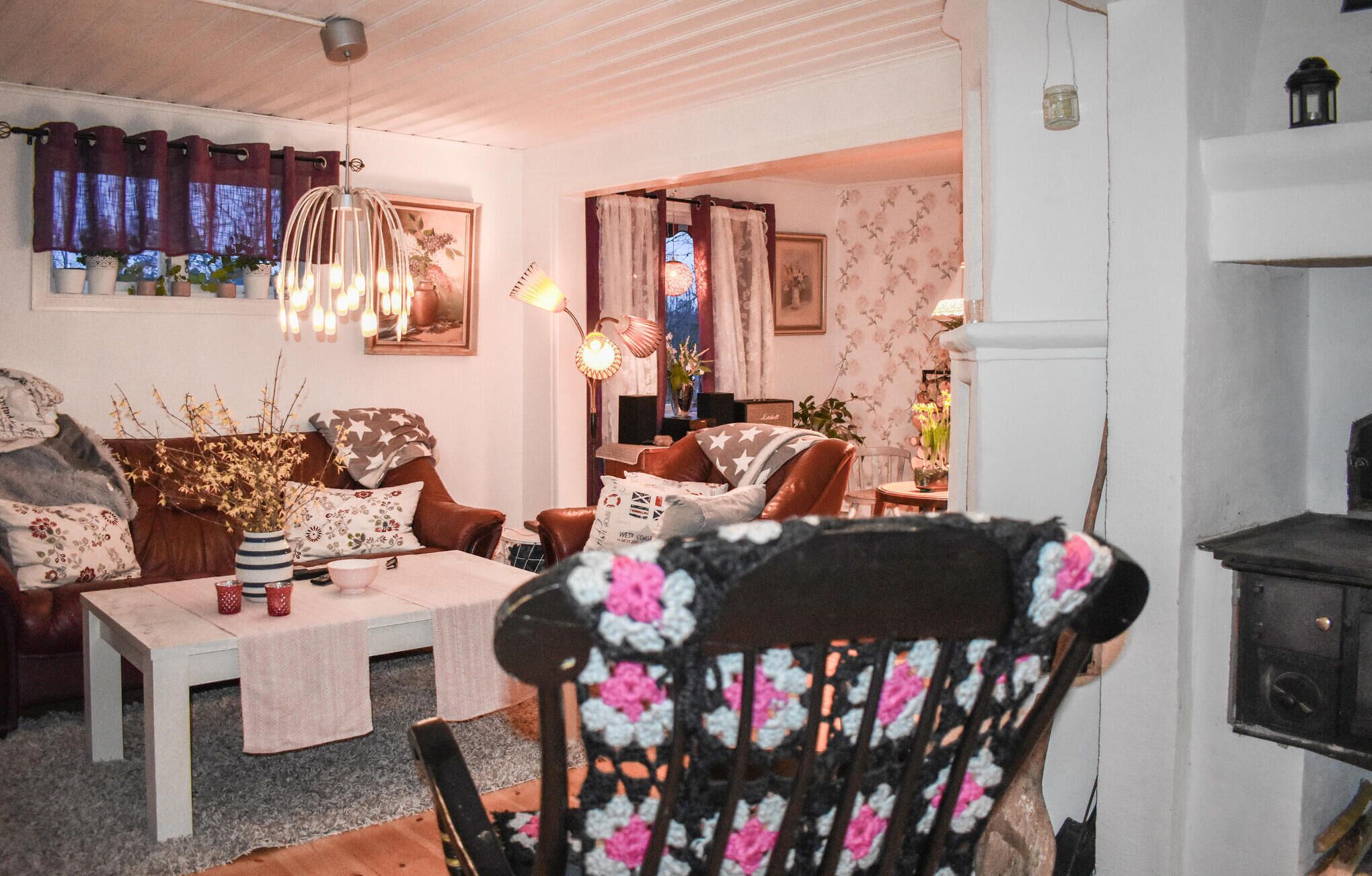 A cozy living room with a dining table, leather chairs, and a fireplace.