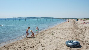 Platja amb gent, un neumàtic i un cel serè.