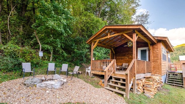 A rustic cabin with a porch, outdoor seating, and a fire pit. - Cottage at the Creek ~ On S. Sylamore (Mountain View)