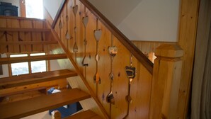 A wooden staircase with heart-shaped cutouts and a wooden handrail. - The Dairy at the Wegmueller Farm - stay on a Wisconsin farm! (Monroe)