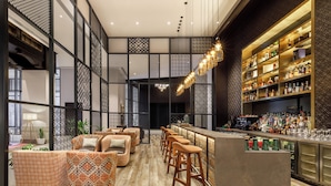 Zona de bar moderna con asientos estampados y una amplia selección de licores.