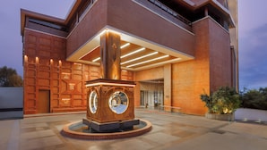 Un edificio moderno con una entrada destacada, una estructura decorativa circular y fachada de ladrillo.