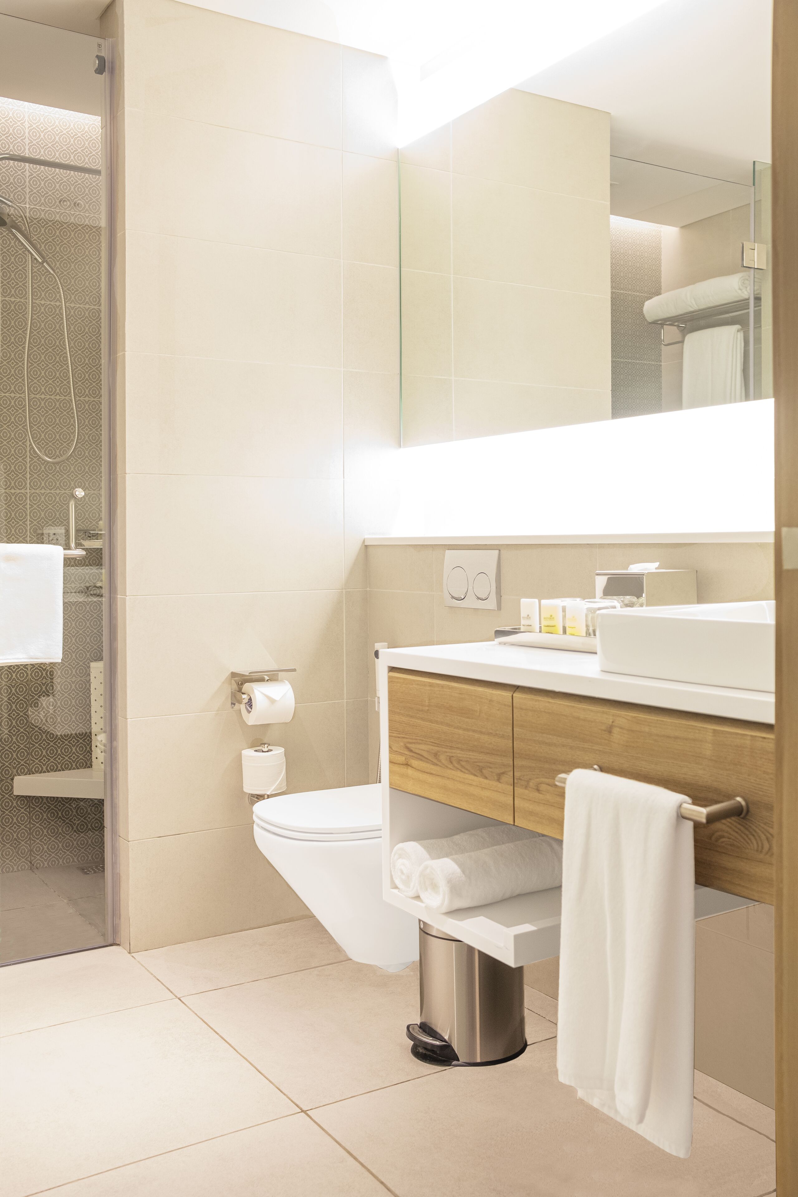 A modern bathroom with a toilet, sink, and shower.