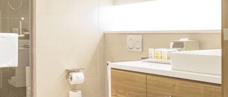 A modern bathroom with a toilet, sink, and shower.