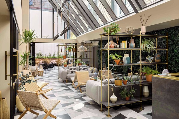 A spacious lounge area with a high ceiling, a checkered floor, and a variety of seating options including sofas and chairs. - Zanzibar Locke (Dublin)