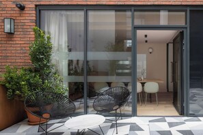 A modern patio with two black chairs, a small round table, and a potted plant. - Zanzibar Locke (Dublin)